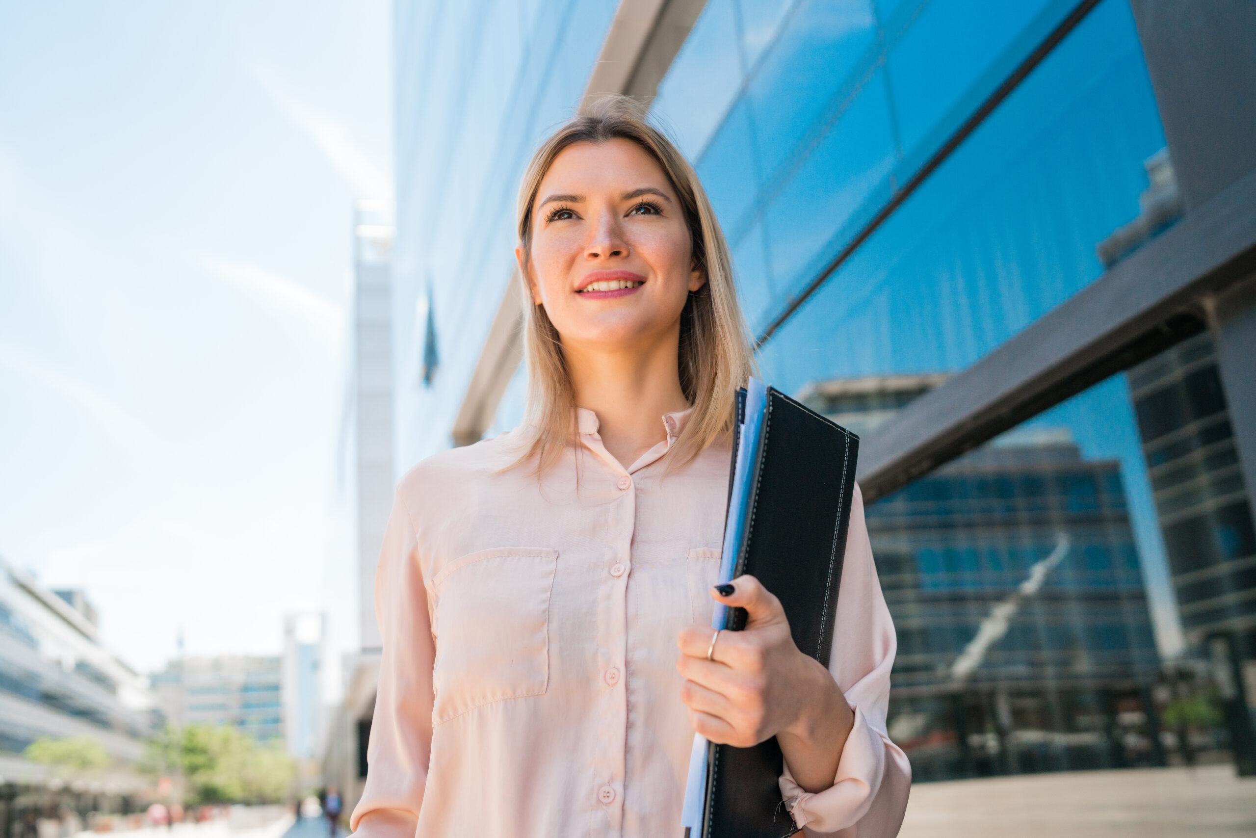 portrait young business woman standing outside office buildings business success concept scaled