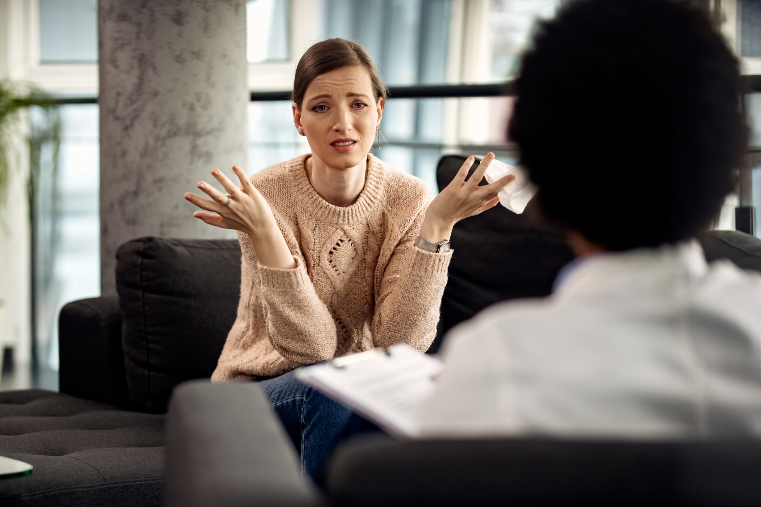 uncertain woman communicating with her psychotherapist doctor s office scaled